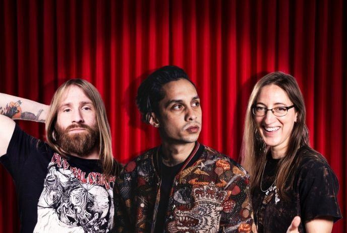 Nick Reynoldson, Jason Allen and Kaitlin Shuvera posing in front of a red curtain.