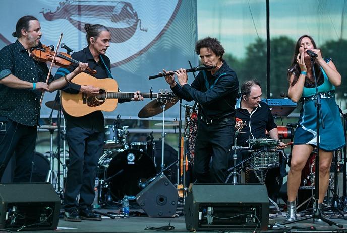 A lively band performs on an outdoor stage.