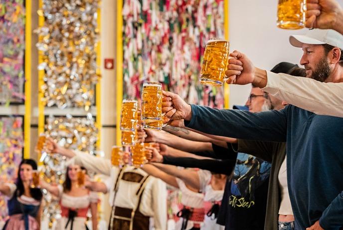 A person raises a glass towards musicians while making a toast.