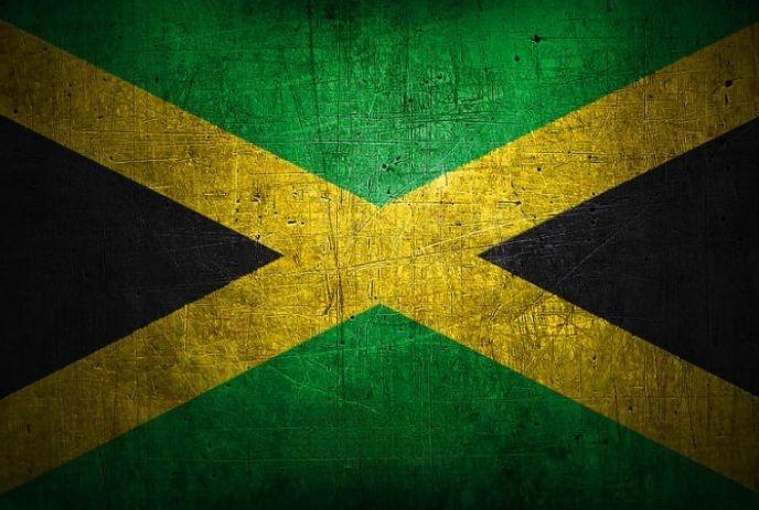 The Jamaican flag with black, green, and gold colours in a textured, weathered design.