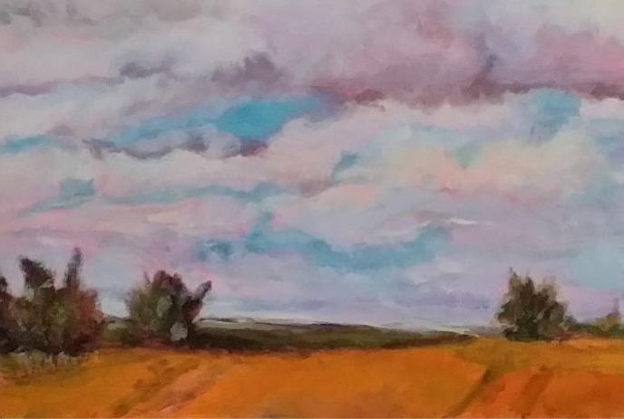 Golden field under a dreamy sky, trees dot horizon, clouds glow pink, purple, blue sunset serenity.