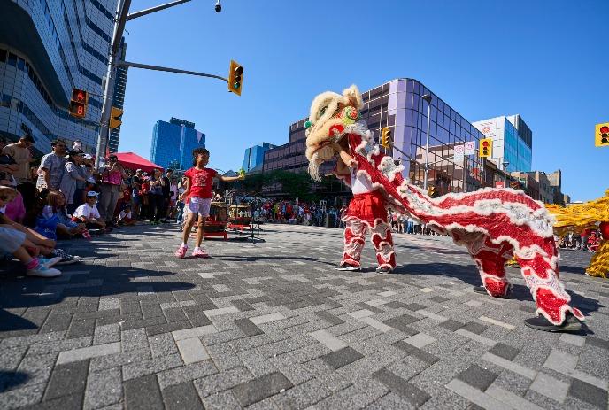 Chinese Dragon performing in Downtown London in front of a crowd of people.