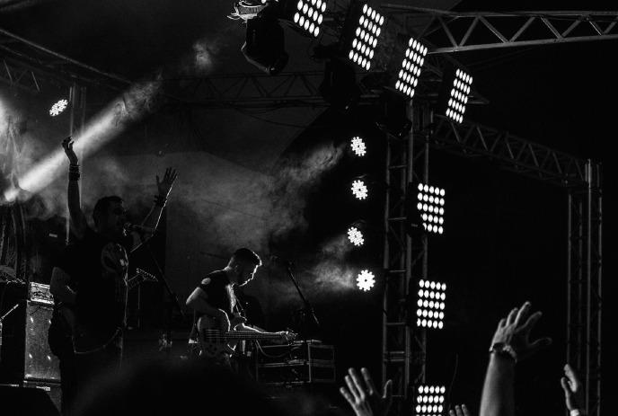 A black and white photo of Texas King performing in front of an audience in a smoky room.