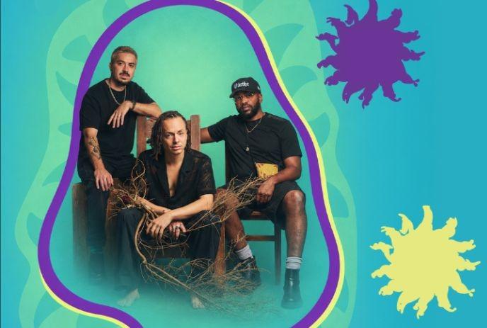 Three musicians pose with natural branches against a colorful teal and purple graphic backdrop.