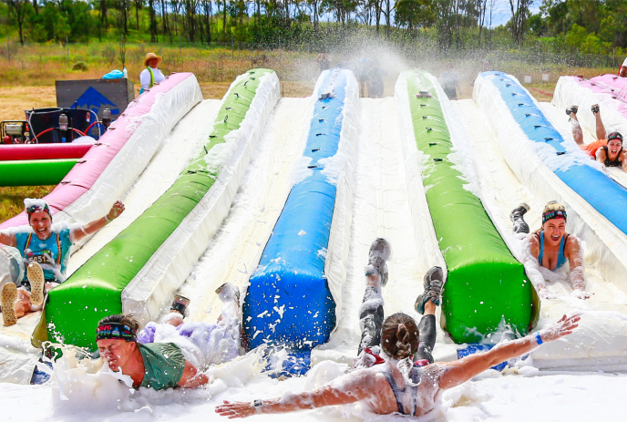 Giant foam waterslides with people going down them.