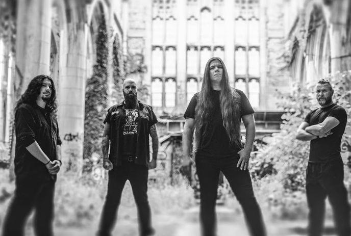 In monochrome, Cryptopsy band wearing black, intense looks, standing in a ruined courtyard, and gothic arches behind them.