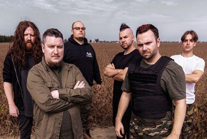 Six artists posing in a field, wearing casual and tactical-style clothing under a cloudy sky.