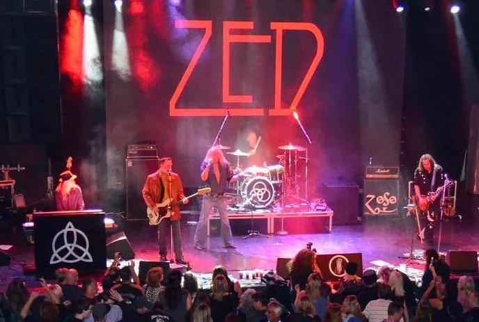 A Led Zepplin tribute band performing on stage in front of a crowd.