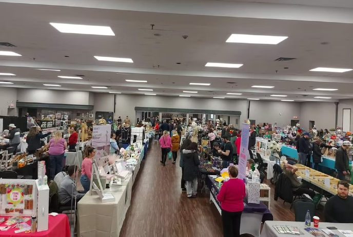 Crowds browse stalls at the London Multi-Vendor Expo in a large, well-lit indoor venue.