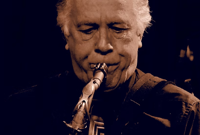 A closeup of Ken Foster playing the saxophone in sephia tone.