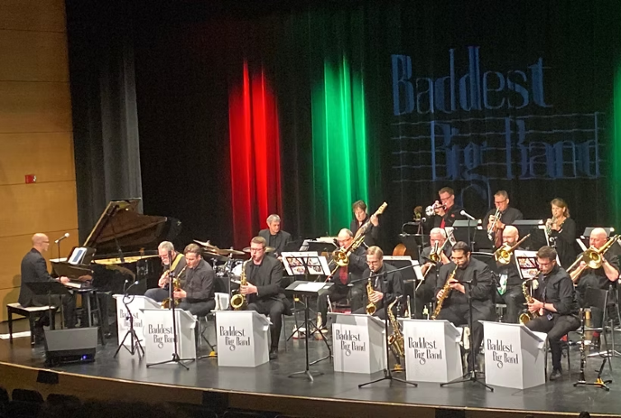 The Baddest Big Band performs on stage with saxophones, trombones, and a pianist.