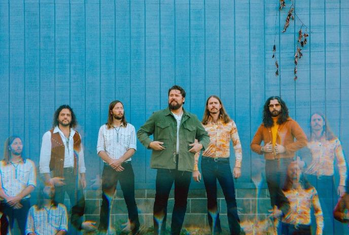 The Sheepdogs: long-haired, bearded men in retro shirts against blue wall with ghostly effect.