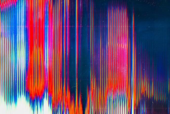 A vibrant, abstract image with colorful vertical streaks and glitch effects on a dark background.