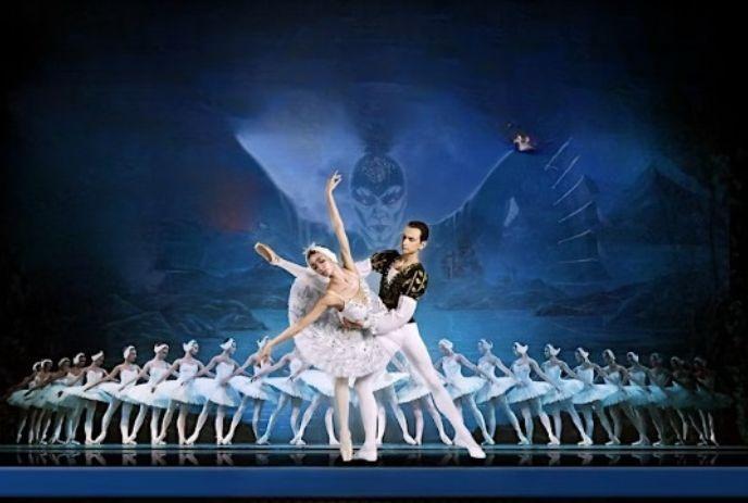 Swan Lake poster with a ballerina, partner, and dancers on a mystical backdrop.