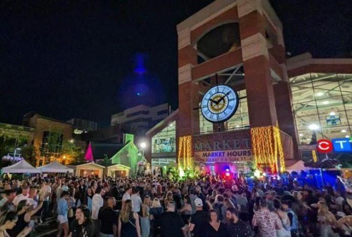 Covent Garden Market lit up with colours at night, with a crowd out front enjoying a previous Elevate Music Festival.