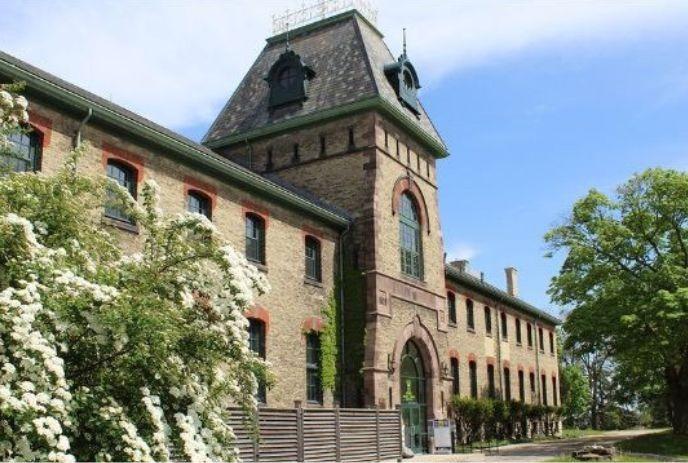 The historic stone facade and distinct tower of the old Infantry School Building at The Royal Canadian Regiment Museum.