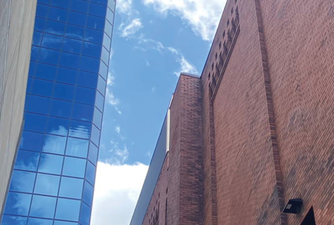 Looking up between the Grand Theatre and another building with windows all the way up.