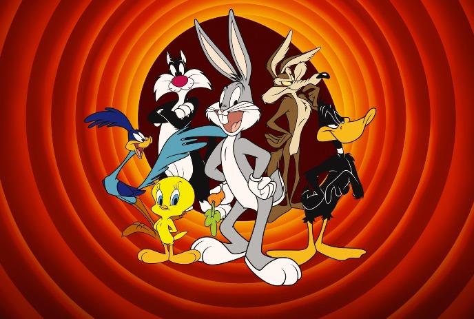 Looney Tunes characters stand together in front of bright red and orange concentric circle backdrop.