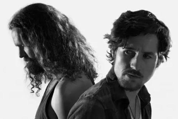 A black and white photo of the two band members of Black Pistol Fire, looking different directions, away from the camera.