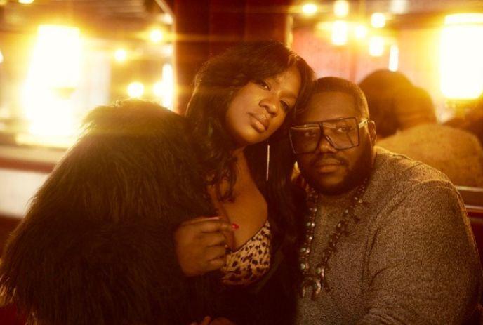 The War and Treaty band members, a woman in fur coat and leopard top leaning on a man with glasses and necklace,