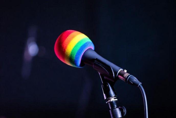 A rainbow coloured microphone on a mic stand.