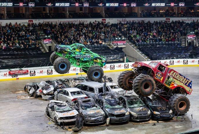 Monster trucks soar over wrecked cars at a previous packed Monster Madness event.