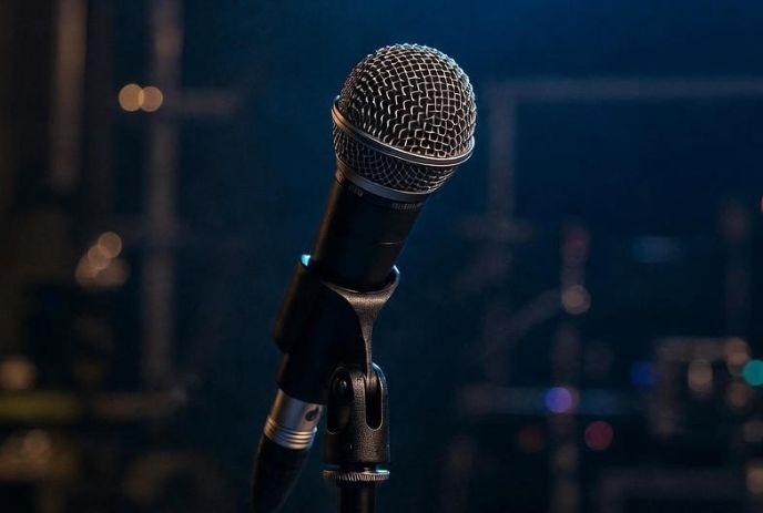 A sharp image of a microphone with a dark blurry background.