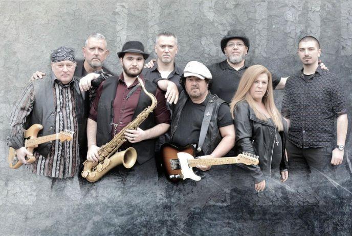 Eight members of the band Duke Street Kings posing together against a textured gray background.