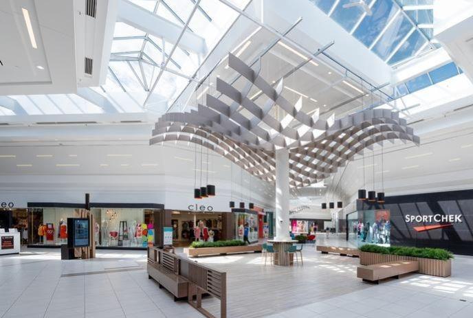 Bright White Oaks Mall interior with modern ceiling, skylights, and benches.