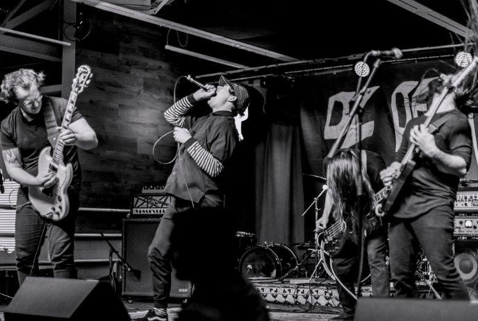 B&W photo of Falls for the Elderly band performing live on stage.