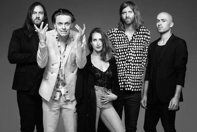 A black and white photo of the 5 members of July Talk, all making different poses while looking at the camera.