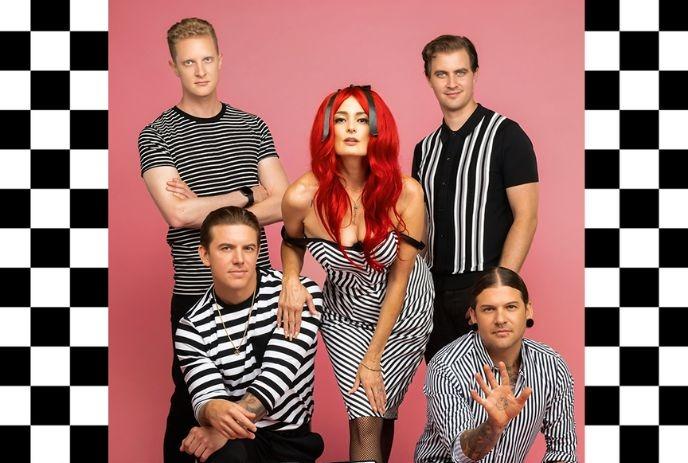 Five people posing in black-and-white striped outfits against a pink background with a checkered border.