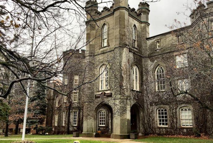 London Old Courthouse a castle-like building, in late fall or winter, with bare trees, ivy-covered stone walls, and towers.