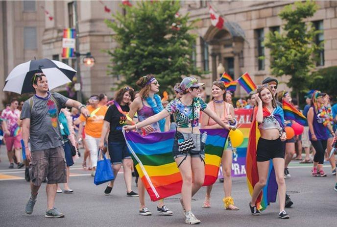 A group of people from the pride parade walking with rainbow flags.