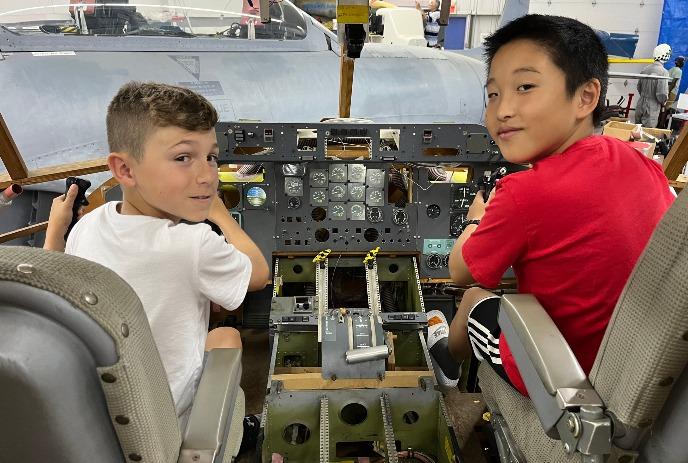 Two children in the cockpit of a plane at the Jet Air Museum.