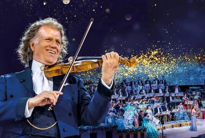 André Rieu with the violin on stage in front of an orchestra.
