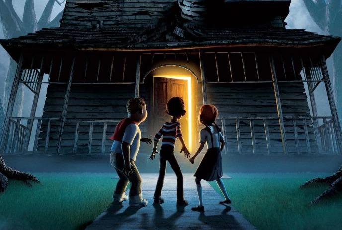 Three young children stand in front of a spooky house with a light shining from inside the door.