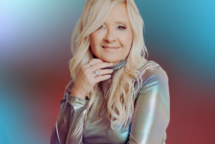Amanda Keeles smiling for the camera in front of a red and blue background.