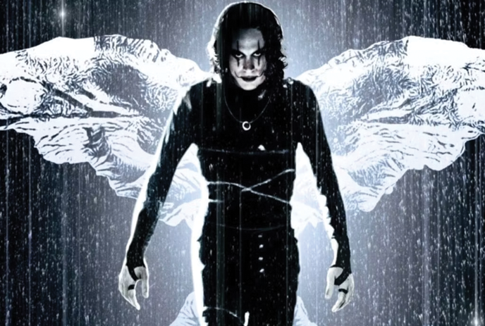 A person in dark clothing and eerie makeup with wings behind them.