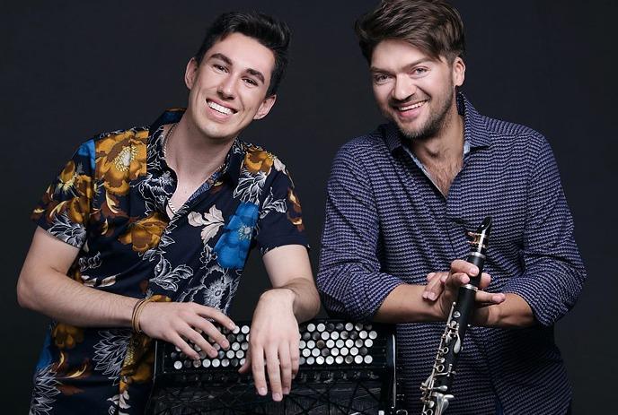 Bridge & Wolak posing for the camera, smiling in front of a black background.