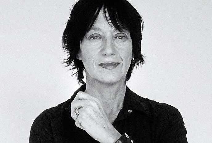 Black and white image of Carole Pope with short dark hair wearing a dark outfit.