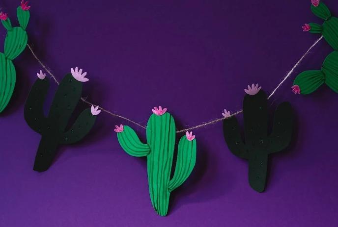 Cactus's on a string against a purple background.