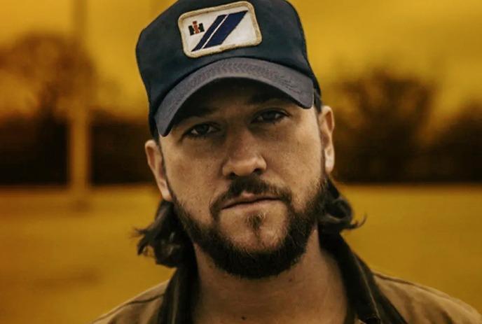 Nate Haller with a beard and cap is centered, with two dynamic poses of him performing, one singing and one playing guitar