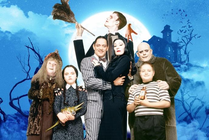 The Addams Family posed before spooky mansion and moonlit sky, showcasing their eerie charm and gothic style.