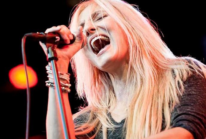 Sass Jordan holding on to a microphone and singing.