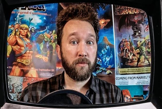 A person on a tv screen with images of He-man cartoons behind them.