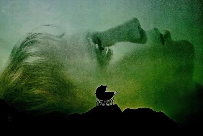 Silhouette baby carriage before large green?toned face creating surreal eerie atmospheric tension.