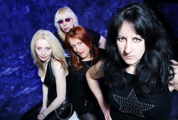 The 4 band members of Girlschool, posing against a purple background.