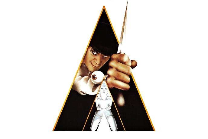 A menacing figure in black grips a knife, looming over a white-clad person framed inside a bold triangular design.