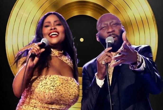 Two people singing passionately into microphones against a backdrop of a large golden record. The mood is lively and celebratory.